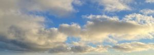 Fluffy white and grey clouds with a glimpse of blue sky